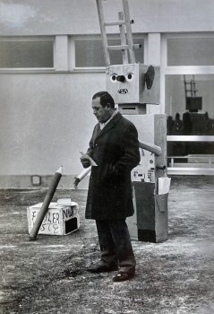 1970 Umzug in das neue Schulhaus 19. Dezember - Vor dem Schulhaus die Begrüssung von Gemeinderat Schmid, hinter ihm ein Schulroboter